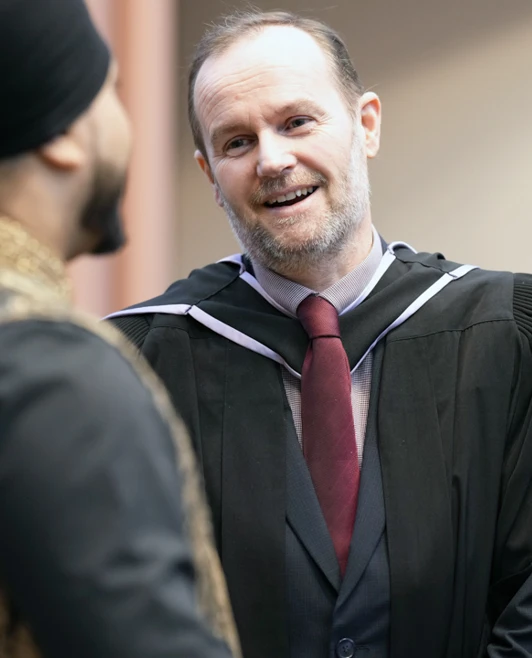 Lecturer in academic gown smiling and chatting with a graduate at Glasgow Kelvin College's 2025 graduation ceremony. Lecturer in academic gown smiling and chatting with a graduate at Glasgow Kelvin College's 2025 graduation ceremony.